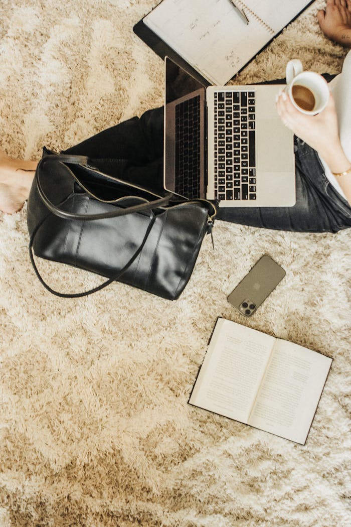 Stylish workspace setup with a leather tote, laptop, and coffee cup for a relaxed work environment.